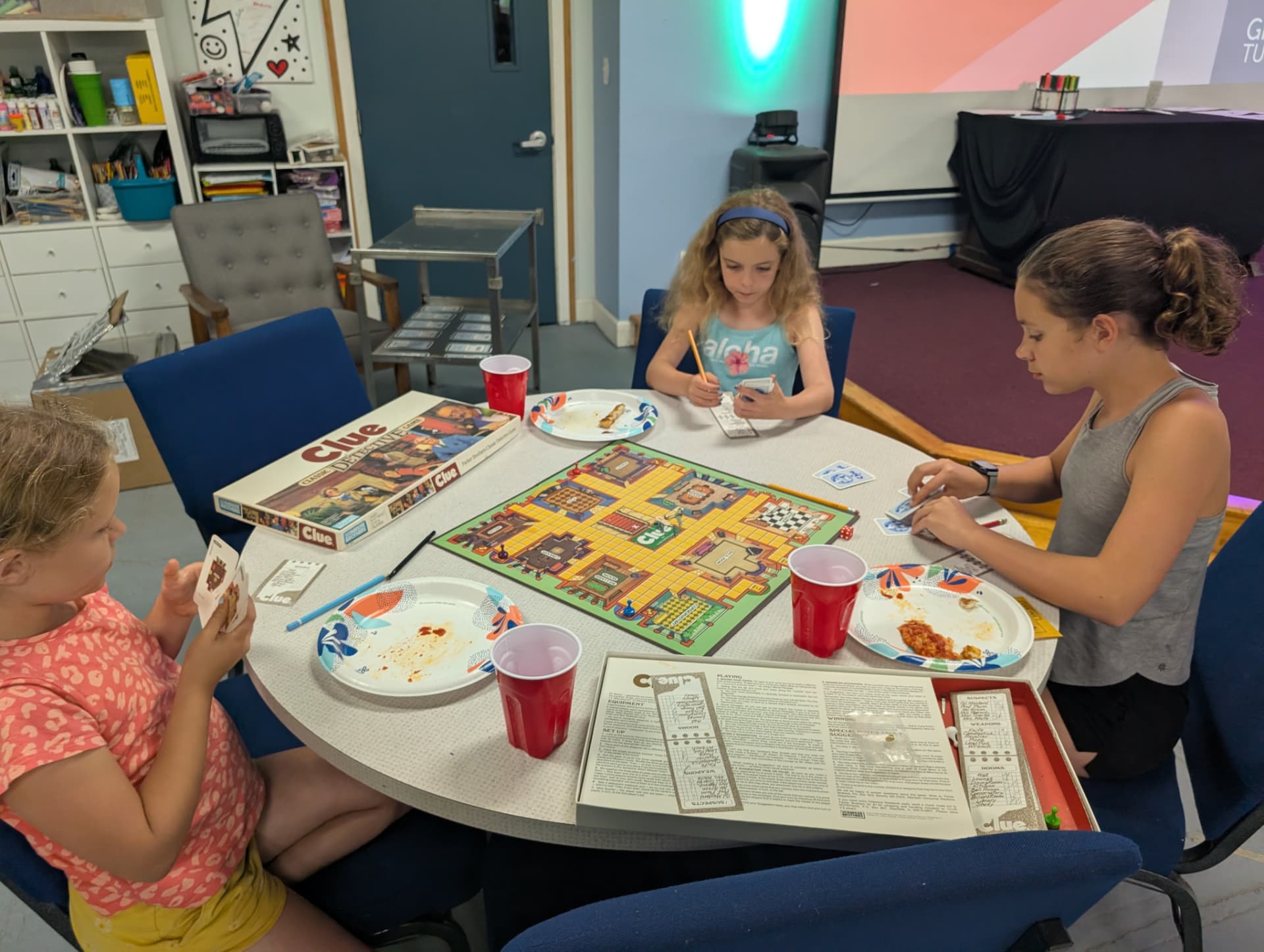 Three children playing a board game together around a table at the Connect Center
